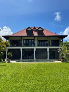 a large house with a green lawn in front of it at Paradise Villa Eden Island in Mahe