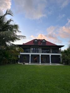 a large house with a green lawn in front of it at Paradise Villa Eden Island in Mahe