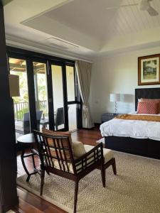 a bedroom with a bed and a chair in it at Paradise Villa Eden Island in Mahe