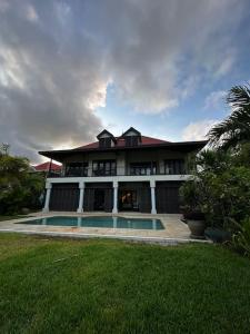 una casa grande con piscina frente a ella en Paradise Villa Eden Island en Mahe