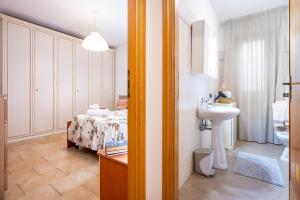 a bathroom with a bed and a sink in a room at La Casetta di Silvia in Piano di Mommio