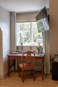 a wooden desk with a chair in front of a window at Munkedals Herrgård in Munkedal