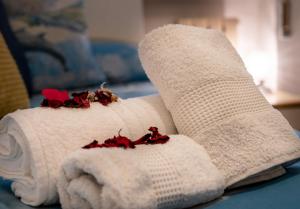 a white towel with red flowers on top of it at La Casetta di Silvia in Piano di Mommio