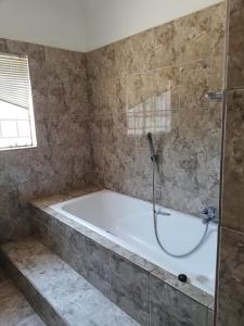 a bath tub in a bathroom with a shower at ANSTA SELF CATERING Home in Outjo