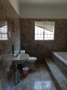 ein Badezimmer mit einem Waschbecken, einem WC und einer Badewanne in der Unterkunft ANSTA SELF CATERING Home in Outjo