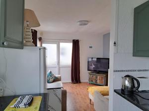 a kitchen with a refrigerator and a living room at Cosy 2-Bed Chalet in Bridlington - Free WiFi in Bridlington