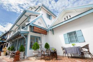 a building with a table and chairs on a patio at Luangprabang D'or Boutique Hotel in Luang Prabang