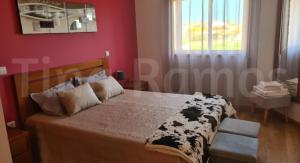 a bedroom with a bed with a black and white blanket at Casa Ramos in Póvoa de Varzim