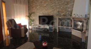 a living room with a fireplace and a television at Casa Ramos in Póvoa de Varzim