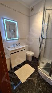 a bathroom with a sink and a shower and a toilet at Casa Ramos in Póvoa de Varzim
