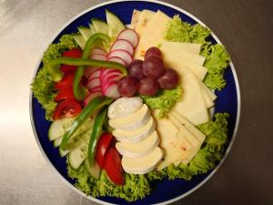 un plato azul de comida con queso y verduras en Hotel Schützenhaus Lenzen en Lenzen