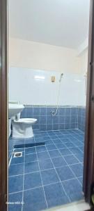 a blue tiled bathroom with a shower and a toilet at Nhật Bình 2 in Ho Chi Minh City