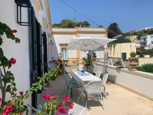 una mesa y sillas con una sombrilla en el balcón en Casa Bernardo by Holiday World, en Castro di Lecce