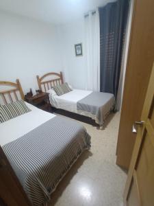 two beds in a room with two beds sidx sidx sidx at Piso Centro Torremolinos in Torremolinos