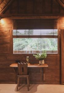 ein Fenster in einem Zimmer mit einem Tisch und einem Stuhl in der Unterkunft Kalyana Villa Gili Air in Gili Air