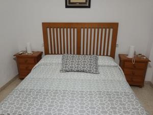 a bed in a bedroom with two nightstands and a pillow at Piso Centro Torremolinos in Torremolinos