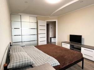 een slaapkamer met een bed en een flatscreen-tv bij 0147 New flat near airport Zhulyany Sofievskaya Borshchagovka in Kiev