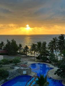 a view of a resort with two pools and the ocean at SANDS AND ROCKS APARTMENT in Mombasa