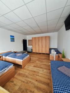 Duży pokój z 3 łóżkami i drewnianą podłogą w obiekcie UBYTOVŇA BYTČA w mieście Bytca