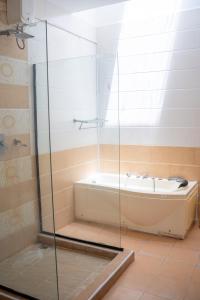 a bathroom with a tub and a glass shower at SANDS AND ROCKS APARTMENT in Mombasa