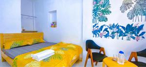 a bedroom with a yellow bed and two tables and chairs at Ngõ Saigon Homestay in Ho Chi Minh City +27 photos