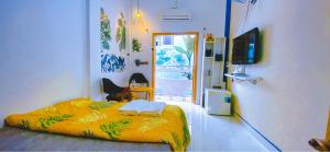 a bedroom with a bed with a yellow blanket at Ngõ Saigon Homestay in Ho Chi Minh City