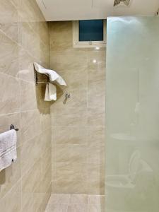 baño con ducha y puerta de cristal en شقة خاصة مؤثثة بالكامل للتأجير اليومي, en Hafr Al Batin