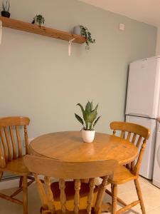 a dining room table with two chairs and a plant on it at Blue Poppy in London