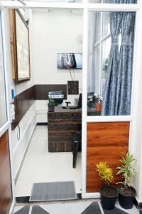 an office with a door and a desk with plants at Shree Home Stay in Ujjain