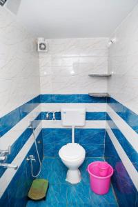 a blue and white bathroom with a toilet and a bucket at Shree Home Stay in Ujjain
