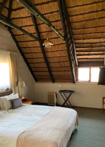 a bedroom with a large bed with a wooden ceiling at Manwood Lodge in Rosetta