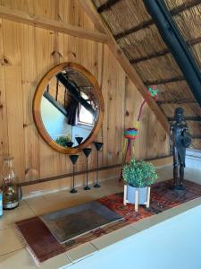 ein Zimmer mit einem Spiegel, einer Statue und einer Pflanze in der Unterkunft Manwood Lodge in Henburg Park