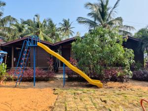a playground with a slide in front of a house at Pousada Donaciana - Beach Cottages in Baga