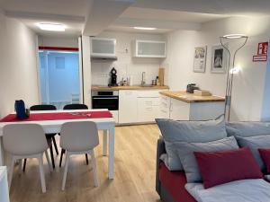 ein Wohnzimmer und eine Küche mit einem Tisch und einem Sofa in der Unterkunft Ferienwohnungen zu St. Johann in Konstanz