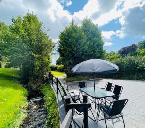 a table and chairs with an umbrella on a patio at River Cottage in Mullingar