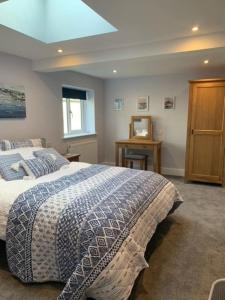 een slaapkamer met een bed met een blauwe en witte deken bij Ramshill House in Cracoe