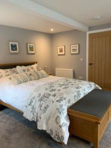 een slaapkamer met een groot bed met een witte en blauwe deken bij Ramshill House in Cracoe