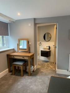 a bathroom with a desk with a mirror and a sink at Ramshill House in Cracoe