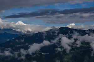 uma vista aérea de uma montanha com nuvens e neve em StayVista's Himalayan Horizon - Mountain & Valley-View Villa with Heater em Gangtok