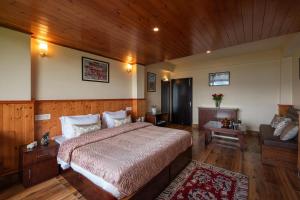 um quarto com uma cama grande e um sofá em StayVista's Himalayan Horizon - Mountain & Valley-View Villa with Heater em Gangtok