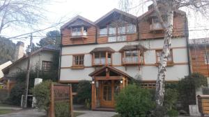 una gran casa de madera con muchas ventanas en Hostería El Arbol Duende en San Martín de los Andes