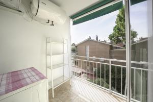 a room with a balcony with a large window at Luz y Color en Castelldefels in Castelldefels