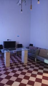 sala de estar con sofá y mesas en un suelo a cuadros en La posada del Kintsugi, en Pilas