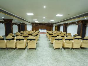 una habitación con hileras de sillas y una mesa en NRS Royal Palace, en Puri