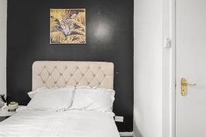 um quarto com uma cama branca e uma parede preta em Hoan Place em Strood