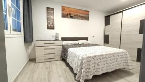 ein weißes Schlafzimmer mit einem Bett, einer Kommode und einem Bett sidx sidx sidx in der Unterkunft Cotufa Garden in La Laguna