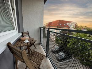 uma varanda com 2 cadeiras, uma mesa e uma janela em City Comfort Retreat em Nové Zámky