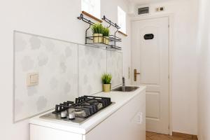 a white kitchen with a stove and a sink at Lexi Apartman private HydroMassage Hot Tub Balatonboglár in Balatonboglár