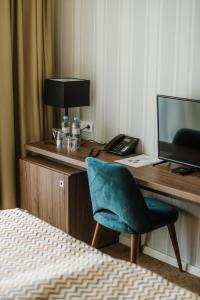 Cette chambre comprend un bureau avec un ordinateur et une chaise. dans l'établissement Hotel Nais, à Niš