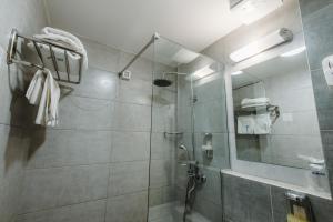 a bathroom with a shower with a glass door at Hotel Nais in Niš